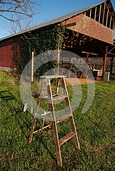Wooden ladder on grass before barn