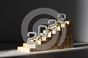 Wooden ladder with grey numbers 2022 on the dark background.