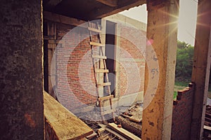 Wooden ladder leans against brick wall at the constructioon site