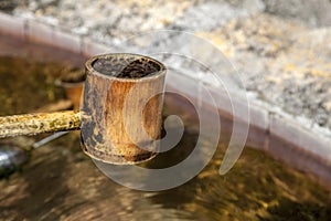 Wooden ladle for bamboo water. Splashes in a bamboo ladle