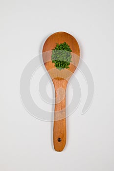 Wooden ladle with green herbs and spices