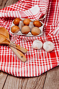 Wooden ladles and eggs on a red and white table rug