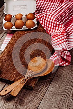 Wooden ladles, garlic and eggs on a red and white table rug