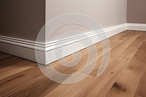 Wooden laminate flooring in a new house with white wall. Baseboard.