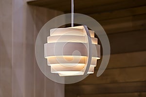 Wooden lamp on a brown background. Modern chandelier of wood in Scandinavian style