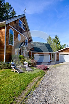 Wooden large American house with natural brown tone with white trim and green summer nature