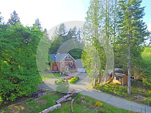 Wooden large American house with natural brown tone with white trim and green summer nature