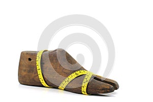 Wooden last shoe with measuring tape on white background