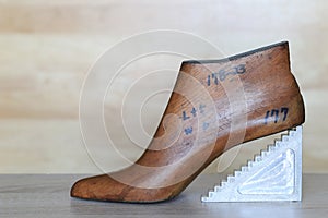 Wooden last shoe on wood background with copyspace