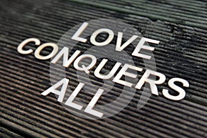 Wooden letter forming the words Love Conquers All