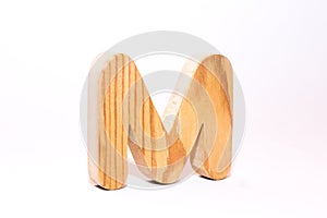 Wooden letter m carved from wood with a beautiful wood texture on a white background