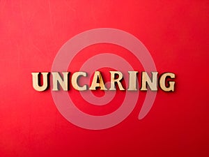 Wooden letters arranged into the word UNCARING