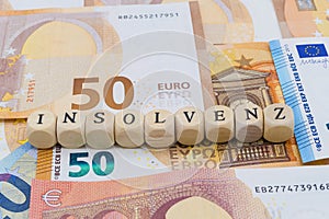Wooden Letters on Banknotes Insolvency german `Insolvenz`