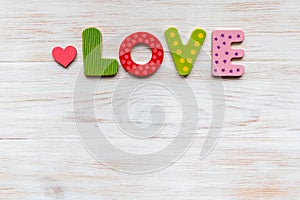 Wooden letters love with heart beside on vintage wooden background. Valentine`s day concept. Top view, copy space