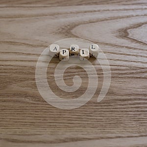 Wooden letters spelling April on a wooden background