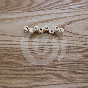 Wooden letters spelling December on a wooden background