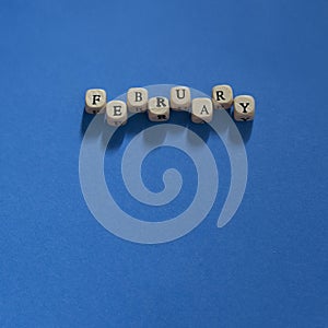 Wooden letters spelling February on a Dark Blue background