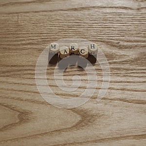 Wooden letters spelling March on a wooden background