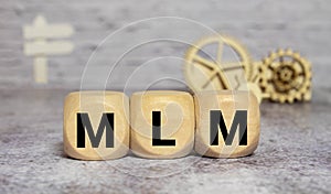 Wooden letters spelling MLM, management concept sign