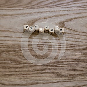 Wooden letters spelling November on a wooden background