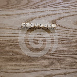 Wooden letters spelling November on a wooden background