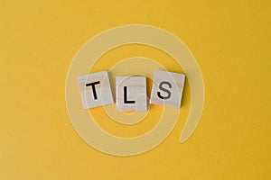 Wooden letters with text TLS stands for Transport Layer Security photo