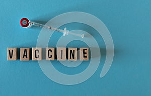 wooden letters VACUNA with a viral and a syringe photo