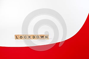 Wooden letters on a white and red background forming the word â€œlockdownâ€. Second wave during Coronavirus pandemic concept