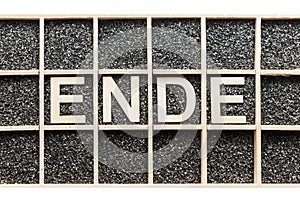 Wooden letters word ENDE in a box