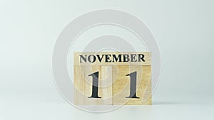 Wooden letters write the word November and the numbers 11 on white background with copy space. 11.11 single day sale
