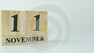 Wooden letters write the word November and the numbers 11 on white background with copy space. 11.11 single day sale