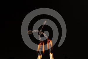 Wooden lighted matches, standing on a black background