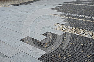 Paving gray brown beige color of natural stone boulders of irregular shapes and colors. Benches around a square and rectangular