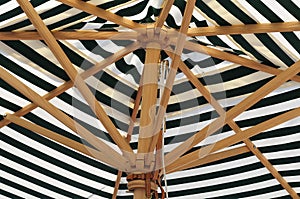 Wooden linkage in a green striped umbrella