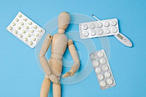 The patient lies next to pills and a thermometer