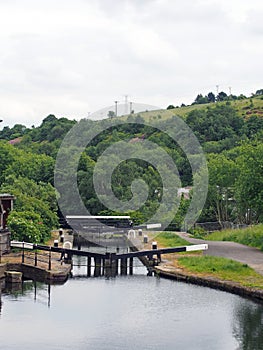 wooden lock gates on the calder and hebble navigation canal in front of the basin in sowerby bridge west yorkshire surrounded by