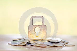 Wooden lock and stack of coins in concept of savings and money growing or energy save.