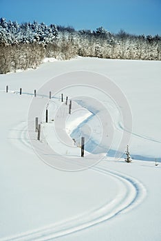 Wooden log fence in a snowy winter landscape