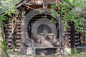 Wooden log hut. Closed doors. Stained glass window