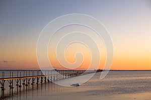 A wooden long bridge at the sea at orange sunset,backgound,texture,wallpaper, amazing romantic view, a path for a walk