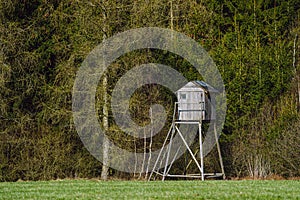 Wooden lookout tower for hunting in the woods and on meadow