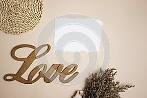 A wooden love letter and flowers over the brown background with copy space.