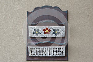 Wooden mail box with compartments for correspondence decorated with flowers drawn by ceramic shards mosaic and written letters