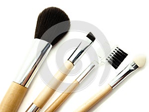 Wooden makeup brushes isolated on white background. Set of powder brush, eye brush, lip brush and eyebrow brush. Makeup kit.