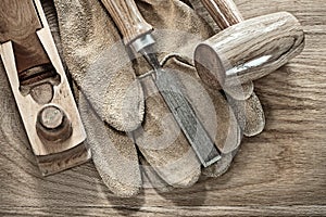 Wooden mallet planer chisel protective gloves on wood board