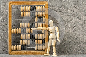 Wooden man counting with old wooden abacus