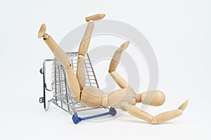 The wooden man fell to the floor from the shopping trolley. Isolated on white background