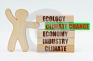 The wooden man moves the green block with the inscription - Climate Change