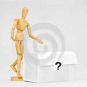 Wooden man next to white box with question mark