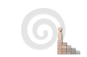 A wooden man stands at the top of a social or career ladder. Concept of business success. Stairs of people. Use other workers